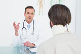 Male doctor in communication with patient at desk