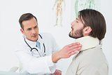 Male doctor examining a patient's neck