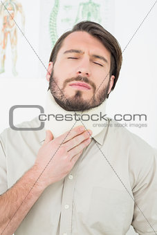 Young man suffering from neck pain with eyes closed