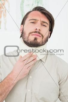 Portrait of a young man suffering from neck pain