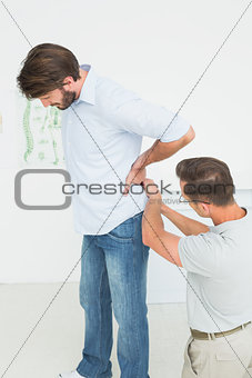 Male physiotherapist examining man's back