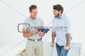 Male therapist discussing reports with a disabled patient
