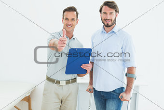 Therapist gesturing thumbs up with disabled patient