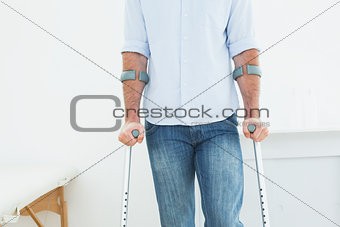 Mid section of a man with crutches in medical office