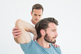 Physiotherapist stretching a young man's arm