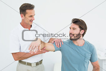 Male physiotherapist massaging a man's arm
