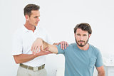 Male physiotherapist massaging a young man's arm