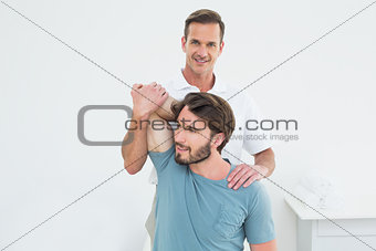 Male physiotherapist stretching a young man's arm