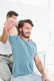 Male physiotherapist stretching a young man's arm