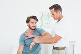 Male physiotherapist stretching a young man's hand