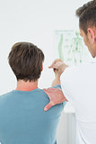 Rear view of a physiotherapist stretching a man's arm