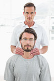 Male therapist massaging a young man's neck