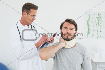 Male doctor examining a patient's sprained neck