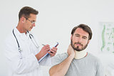 Male doctor examining a patient's sprained neck