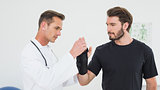 Male physiotherapist examining a man's wrist