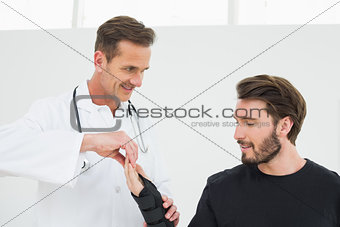 Male physiotherapist examining a young man's wrist