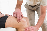 Close-up mid section of a man getting his knee examined