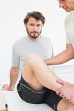 Portrait of a young man getting his knee examined