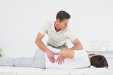 Male physiotherapist examining man's back