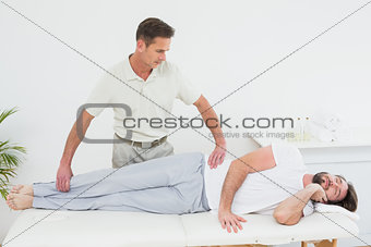 Male physiotherapist examining man's leg
