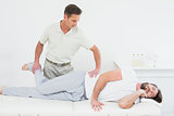 Male physiotherapist stretching man's leg