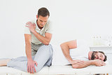 Male physiotherapist examining a young man