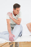 Male physiotherapist examining a young man