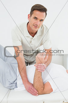 Male physiotherapist examining a man's hand