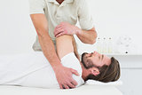 Male physiotherapist stretching a young man's hand