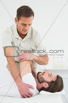 Male physiotherapist stretching a man's hand