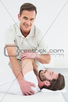 Portrait of a physiotherapist stretching a man's hand