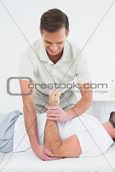 Male physiotherapist examining a man's hand