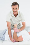 Portrait of a physiotherapist stretching a man's hand