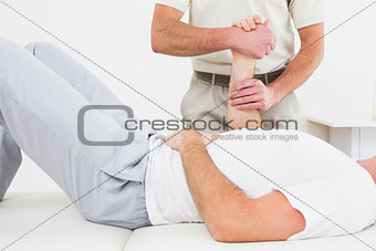 Physiotherapist examining a man's hand