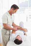 Male physiotherapist examining a young man's hand