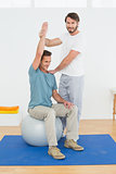 Man on yoga ball working with a physical therapist
