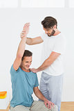 Physical therapist assisting man with stretching exercises