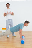Therapist gesturing thumbs up with man doing push ups
