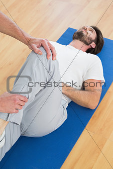 Physical therapist examining man's leg