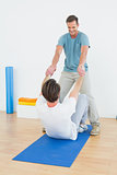 Male therapist assisting man with stretching exercises