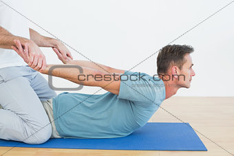 Physical therapist assisting man with stretching exercises
