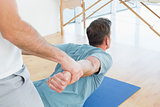 Therapist assisting man with stretching exercises