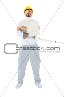 Young man in hard hat with broken hand and crutch