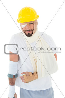 Man in hard hat with broken hand and crutch