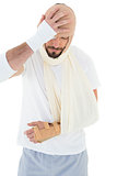 Man with head tied up in bandage and broken hand