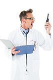 Annoyed doctor with clipboard shouting into a wireless radio