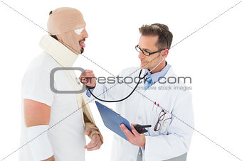 Doctor auscultating patient tied up in bandage with stethoscope