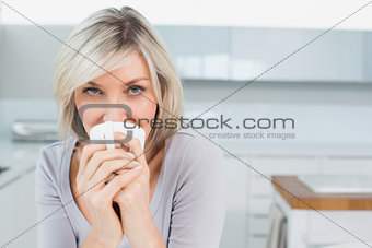 Casual young woman drinking coffee at home