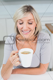 Close-up of a woman drinking coffee in kitchen