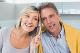 Close-up of a happy couple using telephone in kitchen